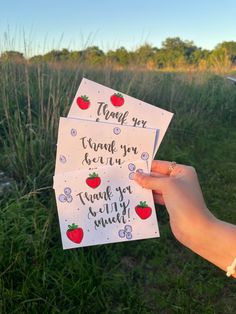 someone is holding up two thank cards with strawberries on them and the words, thank you