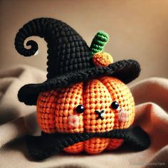 a crocheted pumpkin with a black hat on it's head and nose