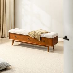 a wooden bench sitting on top of a white carpeted floor next to a window