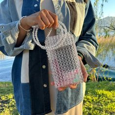 a woman is holding a small purse in her hands