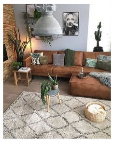 a living room filled with lots of furniture next to a fire place and potted plants