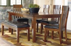 a dining room table with chairs and a potted plant