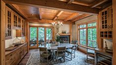 a dining room table and chairs in front of large windows with wood trimmings