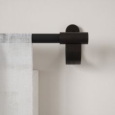 a curtain is hanging on the side of a wall with a black rod attached to it