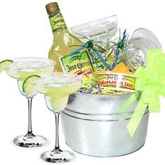 two martini glasses with limeade and bottle in bucket