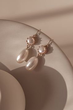 The design of Mira features a freshwater drop pearl suspended from a pearl encased in a 14k gold-filled bezel cup.The gold hook on these earrings is extra fine and comfortable to wear.  A timeless and versatile accessory, these earrings are suitable for any occasion, from formal events to casual outings. Packaged in an elegant plastic-free reusable jewelry box, they make the perfect gift or special treat for oneself.  14k gold-filled components Freshwater pearls Hypoallergenic, suitable for even Classic 14k Gold-filled Pearl Pendant Earrings, 14k Gold Drop Pearl Earrings With Pearl Charm, Timeless Oval Pearl Drop Earrings, Timeless Everyday Pearl Drop Earrings, Timeless Elegant Drop Pearl Earrings, Classic 14k Gold Filled Earrings With Pearl Charm, Classic Pearl Drop Earrings For Everyday Elegance, Timeless Pearl Charm Drop Earrings, Elegant Pearl Charm Earrings In 14k Gold Filled