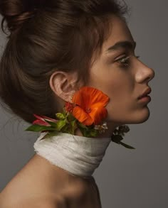 a woman with an orange flower in her hair