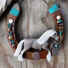 a white horse is standing on top of a wooden board with beads and other accessories