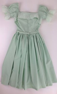 "Super Cute, 1950's ALL COTTON Mint Green Dress with a boxy square neckline & puffy lace sleeves. The neckline & lace sleeves gives this dress a mix between a baby doll dress and a German Fraulein maid dress.. The bodice is fitted with a nipped waist and series of cloth covered buttons up the front with a metal zipper down the back. The pleated skirt is full, and would flare out more with a petticoat. This comes with the original matching cloth covered belt. This dress is hand washable, Vintage Dress With Square Neck, Square Neck Retro Vintage Dress, Retro Square Neck Vintage Dress, Vintage Formal Dress With Square Neck, Skirt Puffy, Mint Green Dress, Baby Doll Dress, Vintage Wardrobe, Maid Dress