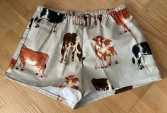 Cows on beige background flannel sleep shorts 100% cotton flannel  Enclosed elastic waistband with 1/2" non-roll elastic Low rise Side seams 2" inseam on all sizes Hip sizing:   XS(32-34"), S(35-37"), M(38-40"), L(41-43") Front rise:  XS(9 3/4"), S(10 1/2"), M(11 1/2"), L(12 3/4") Back rise:  XS(13 1/2"), S(14 1/2"), M(16"), L(16 3/4") Measurements are approximate  Sizing allows for about 2-3 inches of ease/shorts run a size smaller than the pants  All seams are sewn with a serger except for topstitching on waistband and hems. Fabric is not prewashed.  Shrinkage is vertical. Best to wash in cold water separately or with like colors.  Do not soak garment.  Remove promptly into dryer on low heat.  No chlorine bleach. (Shorts run small.) Flannel sleep shorts are not returnable For other impor Cotton Pajama Shorts With Elastic Waistband For Bedtime, Relaxed Fit Shorts With Elastic Waistband For Bedtime, Cotton Shorts With Elastic Waistband For Pajama Party, Relaxed Fit Bedtime Shorts With Elastic Waistband, Relaxed Fit Elastic Waistband Shorts For Bedtime, Beige Cotton Pajama Shorts For Loungewear, Spring Bedtime Shorts With Relaxed Fit, Cotton Shorts For Bedtime, Casual Pajama Shorts With Elastic Waistband For Bedtime