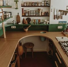 a kitchen with green counters and shelves filled with cooking utensils