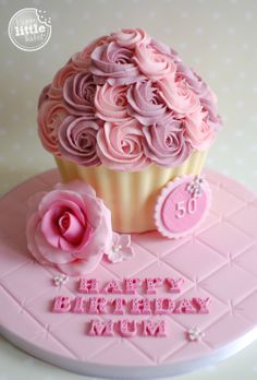 a cupcake with pink frosting and roses on top that says happy birthday mum