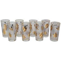 a set of six glass tumblers with gold leaf designs on the bottom and sides