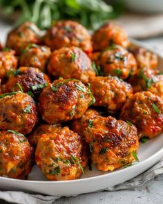 a white plate topped with meatballs covered in marinara sauce and garnished with parsley