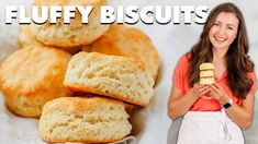 a woman standing next to a pile of biscuits with the words fluffy biscuits on it