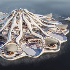 an aerial view of a futuristic building in the water