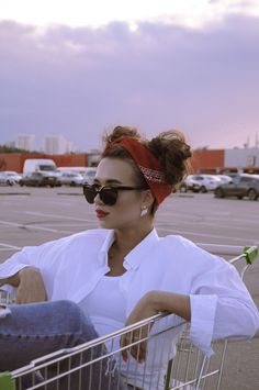 a woman sitting in a shopping cart with her legs crossed and headband wrapped around