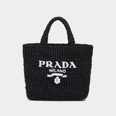 Prada raffia tote bag with woven monogram across front  Flat top handles  Open top  Approx. 9.4"H x 9.4"W x 3.1"D Made in Italy Prada Raffia Tote Bag, Prada Raffia, Raffia Tote Bag, Prada Tote Bag, Embroidered Tote Bag, Embroidered Tote, Straw Handbags, Crochet Tote Bag, Tote Bag Black