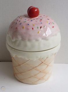 an ice cream container with sprinkles and a cherry on top