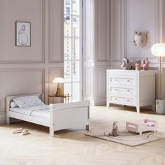 a child's bedroom with pink walls and white furniture, including a small bed