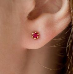 Dainty and elegant ruby stud earrings. Genuine round brilliant cut rubies carefully set in 6 prongs. Made of 14k or 18k solid gold, for a timeless look. The rubies are top quality with a deep pinkish red shade. Their delicate, yet classy design stands out and they will most definitely become one of your favorite jewelry pieces.    ★Details Metal: 14k or 18k yellow, rose or white gold  Stones: Ruby Stone Shape: Round Brilliant  Stone Diameter: approx. 3 mm (0.10 ct) Total Number of Rubies: 2 Total Rubies Weight: approx. 0.20 ct Setting: 6 prongs All the stones we use are 100% natural and genuine. All our items are specially made and hand crafted for you. The design can be made with gemstones of your choosing. Other stones are available upon request. If you would prefer a custom ring, please Red Stone Earrings, Ruby Stud Earrings, Neck Pieces Jewelry, Ruby Earrings Studs, Tragus Earrings, Bridal Gold Jewellery Designs, Star Earrings Stud, Gold Earrings Designs, Silver Jewelry Fashion