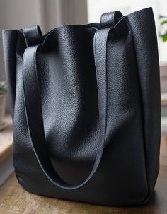 "A large minimal bag on shoulder and hand. Made of black genuine, high quality leather. Inside without lining. Close with two snaps in old gold. Dimensions: Width 32 cm (12,6 \"), Height 38 cm (15\"), depth about 11 cm (4,3\") shoulder straps 65 cm ( 25,5\") Standard delivery time: European union: 4 - 10 days Europe (not EU): 7 - 14 days U.S.A., Canada: 10 - 20 days Australia, South America, Asia, India, North Africa: 1 - 3 weeks We send all items with priority air mail and tracking number." Minimalist Black Shoulder Bag With Smooth Grain, Minimalist Smooth Grain Shoulder Bag For Shopping, Black Smooth Grain Hobo Bag For Business, Black Smooth Grain Hobo Bag For Daily Use, Black Smooth Grain Hobo Bag For Everyday, Minimalist Leather Hobo Bag Tote, Minimalist Smooth Grain Tote Shoulder Bag, Black Smooth Grain Hobo Bag, Everyday Black Smooth Grain Hobo Bag