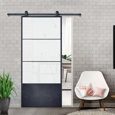 a living room with white brick walls and black sliding doors