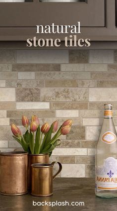 a bottle of natural stone tiles next to a vase with tulips in it