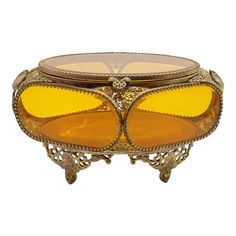 an ornately designed glass and metal table with yellow tinted glasses on it's sides