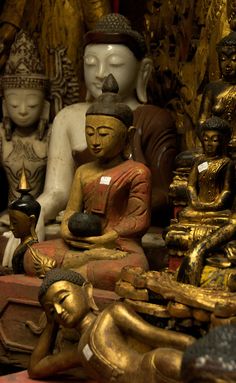 many buddha statues are on display in a store