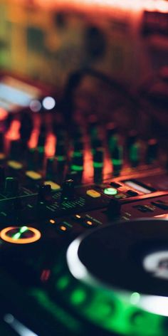 a close up of a dj's turntable with lights in the back ground