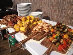 a table topped with lots of food on top of wooden skewered skewers