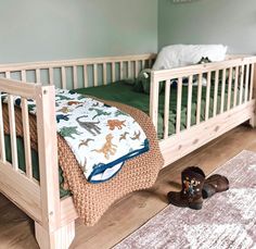 a toddler's bed with shoes on the floor next to it and a rug