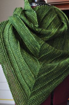 a green knitted shawl draped over a table