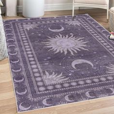 a purple rug with sun and moon designs on it in a living room next to a chair