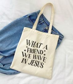 What A Friend We Have In Jesus Tote Bag DETAILS: Material: 100% cotton Heavy fabric (12 oz/yd² (406.9 g/m Reinforced stitching on the handles Durable Easy to carry Perfect for everyday wear DIMENSIONS: 15in x 16in 20in handles CARE INSTRUCTIONS: Do not iron directly over the printed area - print may stick to the iron Spot clean; do not bleach PLEASE NOTE: This item is printed on demand (made and shipped directly from a partnering manufacturer), so please allow 3-5 days for order processing before shipping. Apparel orders will not be packaged in Meli & Olive branding, which usually includes a thank-you card and a freebie sticker. Only orders for stickers, stationery, and keychains will come in our branded packaging, shipped directly by me (Ciara). If you're ordering both apparel and sticker Cotton Shoulder Bag With Letter Print, White Cotton Shoulder Bag With Letter Print, Eco-friendly Cotton Canvas Bag With Letter Print, Everyday Cotton Shoulder Bag With Letter Print, White Cotton Bag With Letter Print, Trendy Cotton Shoulder Bag Gift, Eco-friendly Canvas Tote Bag With Letter Print, Everyday Cotton Bags With Letter Print, Everyday Cotton Bag With Letter Print