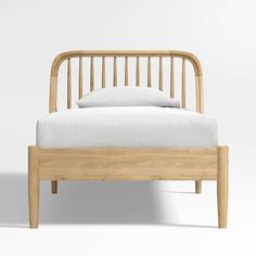 a wooden bed frame with white sheets and pillows