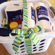 a laundry basket filled with toiletries and wrapped in green and white paper towels tied to the handles