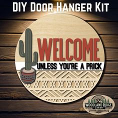 a wooden sign that says welcome to the door hanger kit with a cactus on it