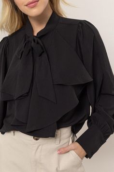 Get ready to add some playful flair to your wardrobe with our Ruffles Blouse! Featuring long balloon sleeves with buttoned cuffs, a pretty tie-neck, and gentle ruffles at the front, this blouse brings fluttery movement to any outfit. The button-down bodice offers a classic fit and ends with a rounded hem for a stylish touch. 100% Polyester Fall Workwear Blouse With Ruffle Hem, Fall Puff Sleeve Blouse With Bow, Fall Puff Sleeve Blouse With Bow Detail, Fall Blouse With Pleated Sleeves And Ruffled Collar, Workwear Blouse With Ruffles And Balloon Sleeves, Elegant Fall Blouse With Ruffle Hem, Chic Ruffled Office Blouse, Formal Ruffled Puff Sleeve Blouse, Formal Puff Sleeve Blouse With Ruffles