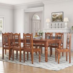 a dining room table and chairs in front of a fireplace