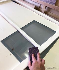 a man is working on a white counter top with two square pieces of glass in front of it