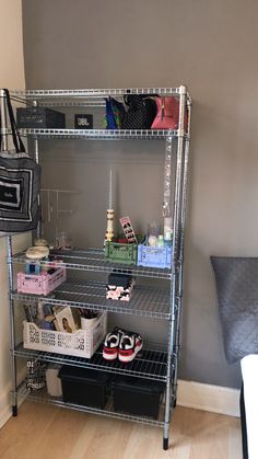 a metal shelving unit with shoes and bags on it