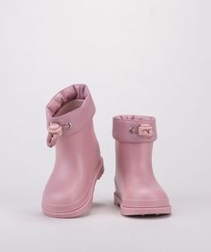 a pair of pink rain boots sitting on top of a white floor