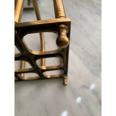 a close up of a metal object on a marble floor with white and gold paint