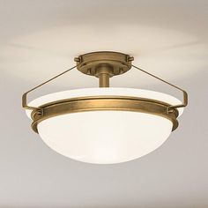 an overhead light fixture with a white glass shade on the top and bottom part of it