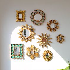 there are many different pieces of art on the wall together, including mirrors and brooches