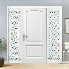 a white door in a room next to a vase with flowers