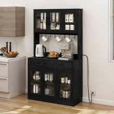 a black cabinet with coffee cups and other items on it next to a white kitchen counter