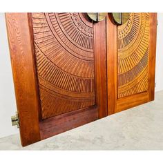 two wooden doors with intricate designs on the front and back sides, one is open